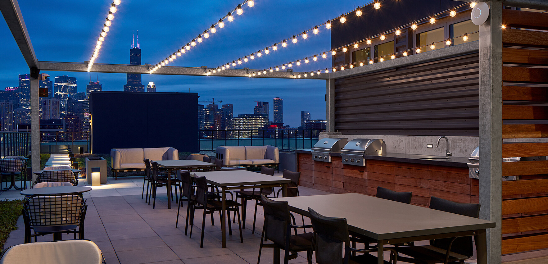 Twilight transforms our rooftop terrace into a serene haven, where city views and the soft glow of evening skies set the scene for peaceful moments.